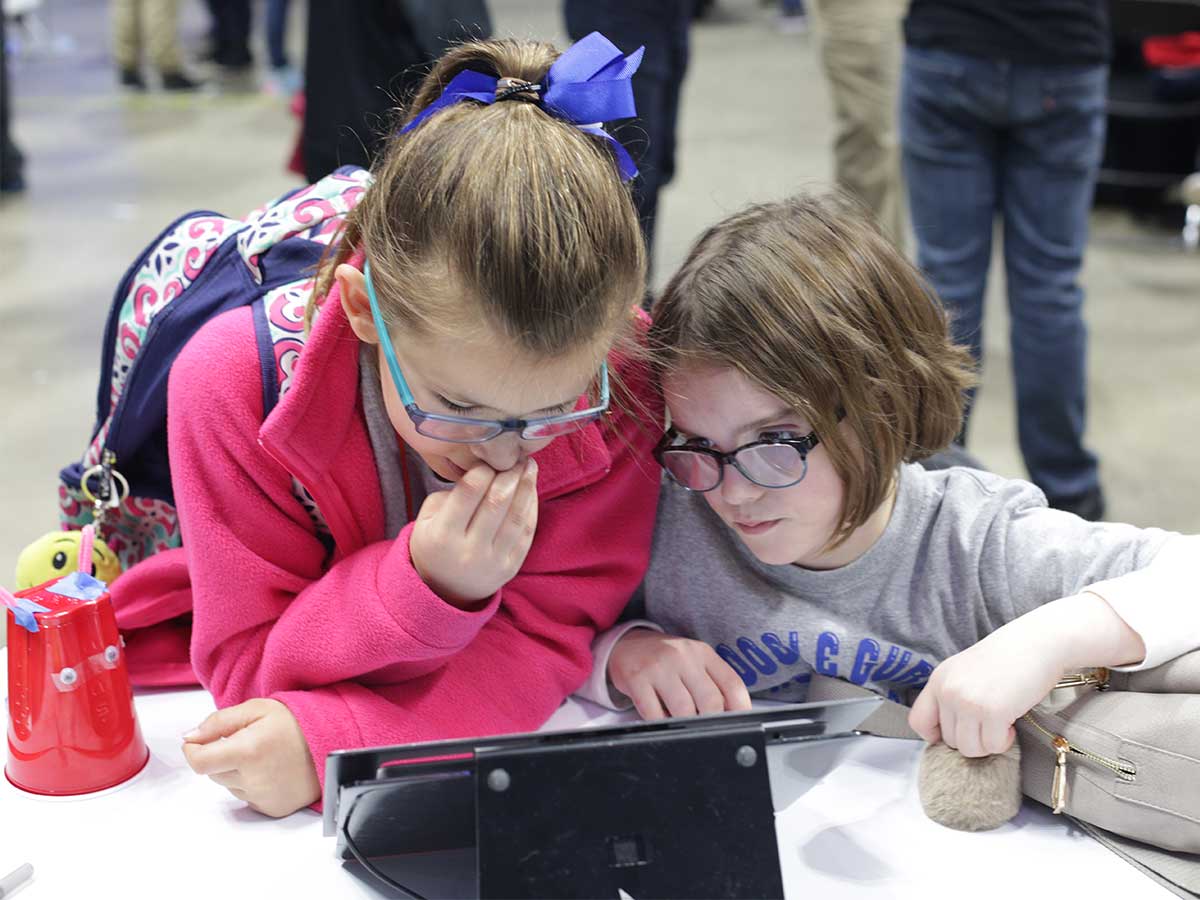 Girls solving coding challenge at STLP event