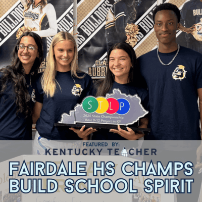 Four Fairdale High School students smile while holding their STLP 2025 State Championship trophy for “Best 9-12 Project in KY.” They stand in front of posters of Fairdale athletes, wearing matching navy shirts with the Bulldogs logo. The image includes a graphic overlay reading: “Featured by Kentucky Teacher – Fairdale HS Champs Build School Spirit.”